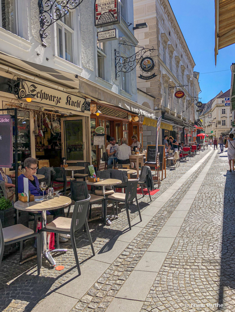 Narrow street with outdoor restaurants.