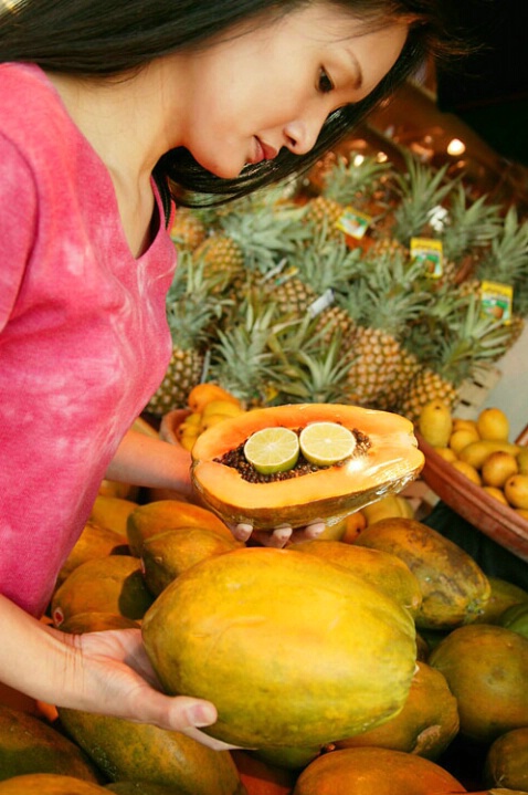 Asian Woman shopping for tropical fruits