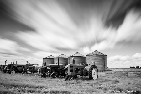 Clouds passing by antique tractors