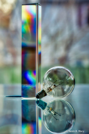 A prism and a light bulb on glass