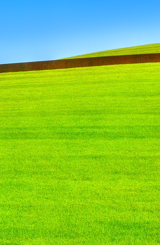 Blue Sky, Brown Wall and Grassy Knoll