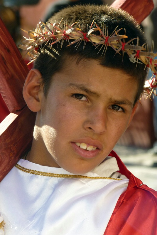 Boy carrying a cross