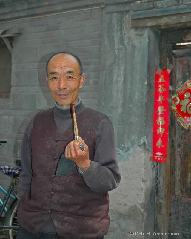 Chinese man and pipe in Beijing Hutong
