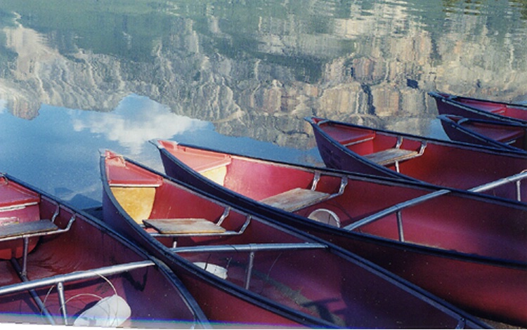 Red boats with mountain reflection