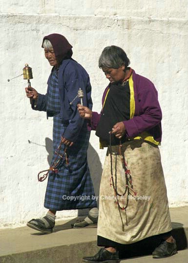 2 women spin prayer wheels, Bhutan, 18-8