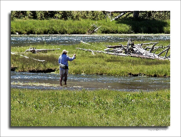 Fly fisherman works Firehole River