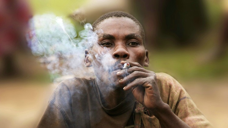 Smoke: Batwa Pygmy man outside Bwindi
