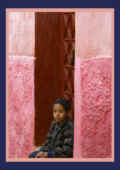 Little boy in a red doorway of Marrakesh