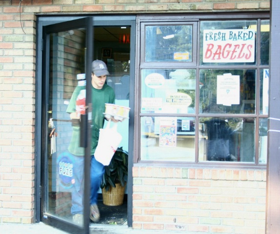 Customer Leaves Bagel Giant With Bagel and Coffee 