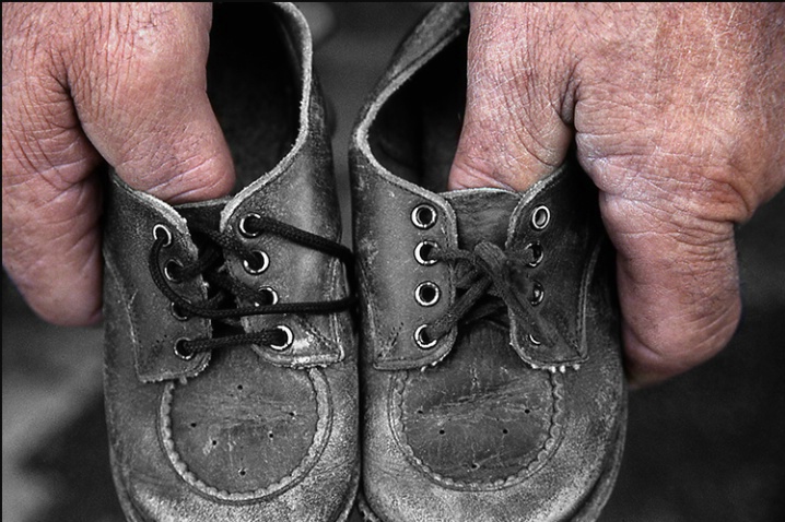 Dad Holding Baby Shoes