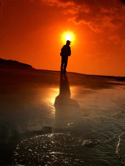 a man walking alone on the beach