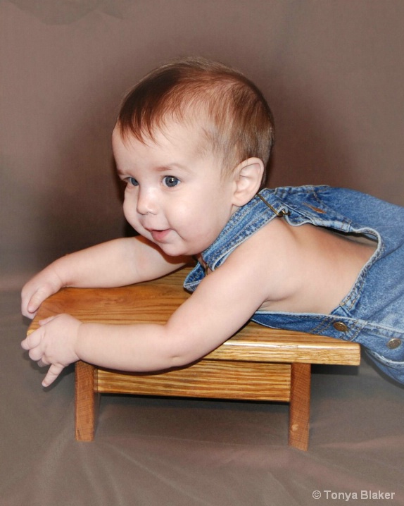 Owen 6 months lying on wooden stool
