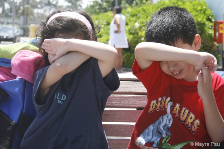 Kids covering thier eyes from the sun