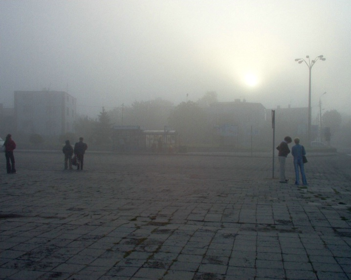 People waiting for a bus on a foggy day