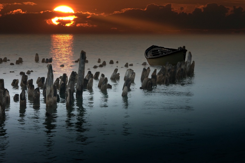 Sunset with boat and pilings