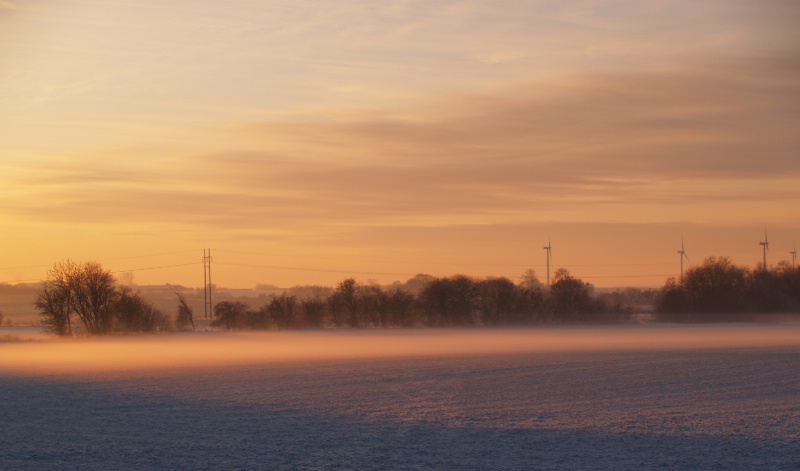 Freezing fog and snow on the fields at sunset