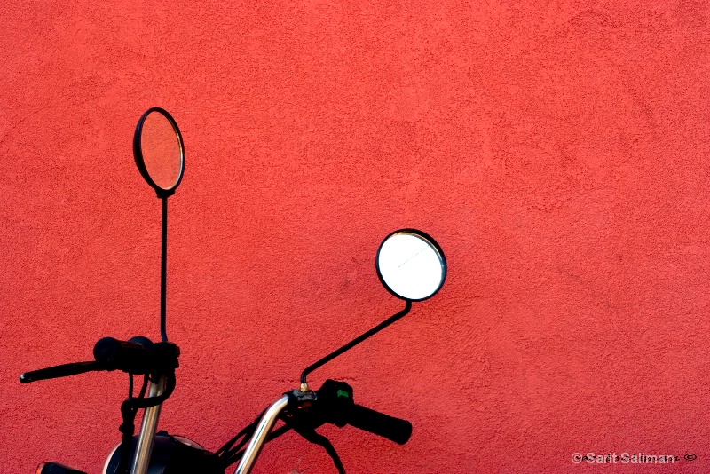 still life motorbike on a red wall