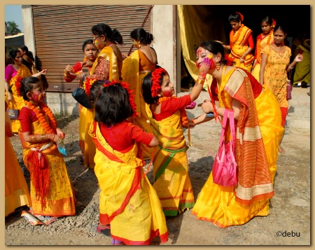 Cute little girl playing Holi with her mother