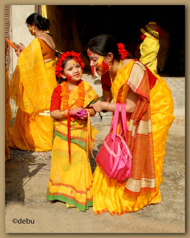 Cute little girl playing Holi with her mother