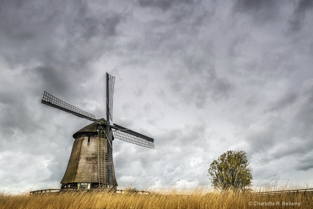 Traditional Dutch windmill against a stormy sky