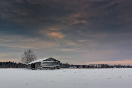 Snow Covered Barn House Under Dramatic Skies