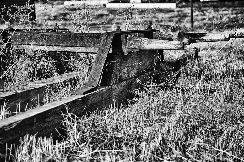 A very old and decaying wagon in a field