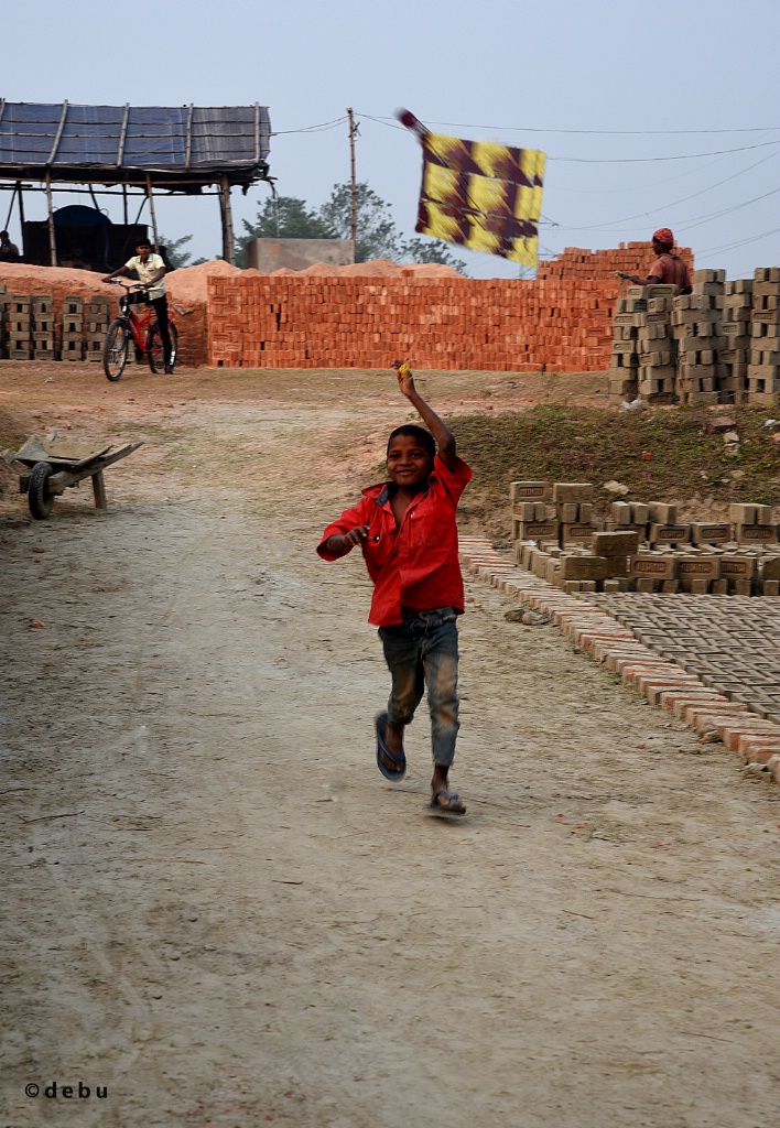 Poor  Indian village boy playing with a Kite