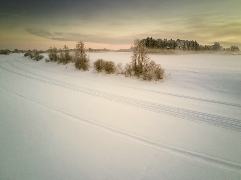 Snow Mobile Tracks On An Icy River