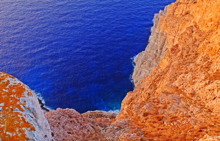 Sunbathed rocks at the edge. Folegandros island.