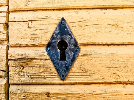 Iron Keyhole In A Yellow Wall